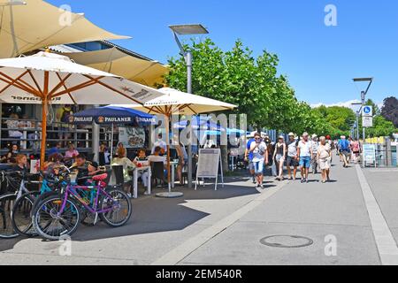 Konstanz, Deutschland - Juli 2020: Touristische Straße mit Outdoor-Cafés und Menschen am Hafen am Bodensee an sonnigen Sommertag Stockfoto