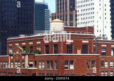 Wassertank auf einem Penthouse auf dem Dach eines älteren Gebäudes zwischen Wolkenkratzern in Midtown, New York, NY, USA Stockfoto