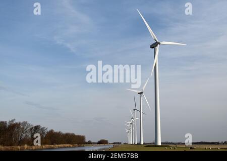 Eine Reihe von Windkraftanlagen Stromerzeuger drehen neben einem Holländischer Kanal Stockfoto