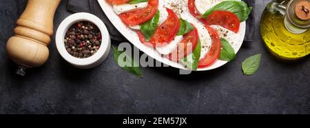 Köstliche italienische Caprese Salat mit reifen Tomaten, frischer Basilikum und Mozzarella. Ansicht von oben flach Stockfoto