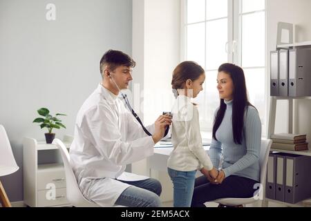 Hausarzt, Hausarzt oder Kinderarzt, der auf die Lungen des kleinen Patienten hört Stockfoto