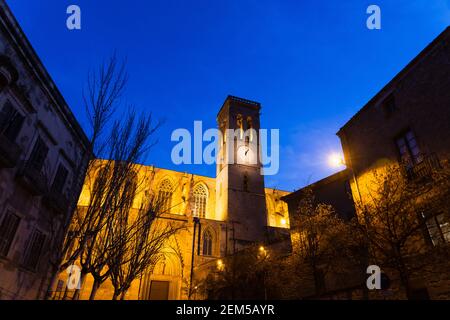 MANRESA, SPANIEN - 10. JANUAR 2018: Alte mittelalterliche gotische katholische Kirche in der Altstadt von Manresa, Spanien. In der Nacht leuchten gelbe Leuchten auf dem Stockfoto