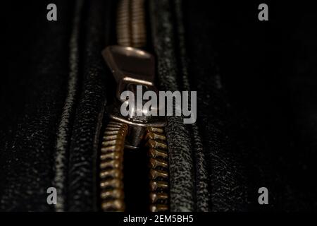 Detail der Verriegelung Reißverschluss auf schwarzem Leder Jacke. Nahaufnahme der Makro-Aufnahme mit lokalem Fokus. Vertikale Makrofotografie. Stockfoto