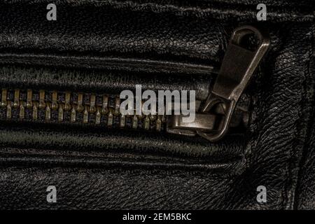 Detail der Verriegelung Reißverschluss auf schwarzem Leder Jacke. Nahaufnahme der Makro-Aufnahme mit lokalem Fokus. Vertikale Makrofotografie. Stockfoto