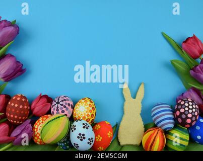 Tulpen, Primeln, bemalte Eier und Häschen-förmige Kekse Stockfoto