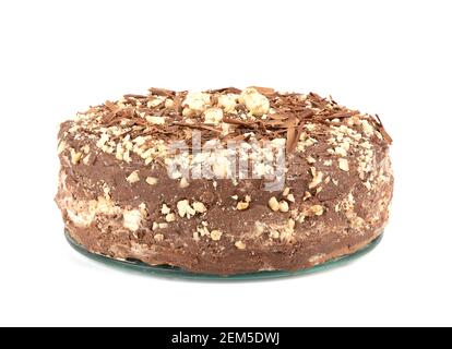 Cremiger Kuchen mit Schokoladenstückchen und Haselnüssen bestreut. Cremiger Kuchen isoliert auf weißem Hintergrund. Hausgemachter Kuchen. Stockfoto