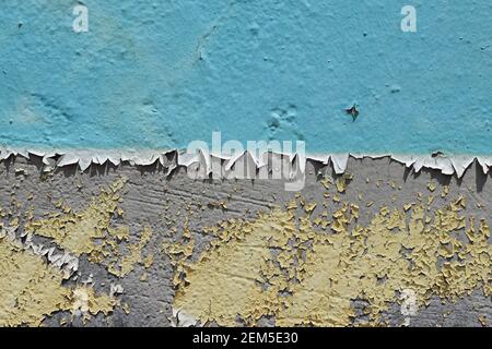 Schichten von abblätternder Farbe auf texturiertem zweifarbigem Wandhintergrund. Stockfoto