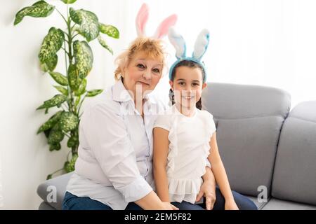 Frohe Ostern. Familie Großmutter und Kind Enkelin mit Ohren Hase machen sich bereit für den Urlaub Stockfoto