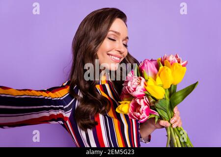 Foto-Porträt von Mädchen halten Blumen Bündel lächelnd verträumt nehmen Selfie isoliert lebendige violette Farbe Hintergrund Stockfoto