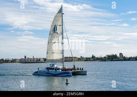 Touristisches Katamaran-Segelboot in der Mission Bay von San Diego, Kalifornien, USA. Segel-Katamaran mit weißen Segeln auf ruhigem Wasser. Luxus-Katamaran ex Stockfoto