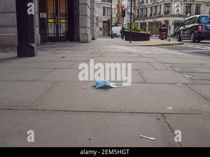 London, Großbritannien. Februar 2021, 24th. Eine weggeworfene Gesichtsmaske auf dem Boden im Zentrum Londons.England wird ab März in mehreren Phasen mit der Lockerung der Sperrungsbeschränkungen beginnen.Geschäfte, Bars und Restaurants werden voraussichtlich im April wiedereröffnet. Kredit: Vuk Valcic/SOPA Images/ZUMA Wire/Alamy Live Nachrichten Stockfoto