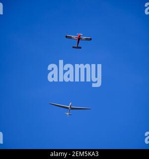 Segelflugzeug gezogen von einem kleinen Flugzeug unter einem klaren Blauer Himmel Stockfoto