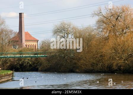 Der Fluss Lea im Winter in der Nähe von Walthamstow Wetlands, mit dem historischen Maschinenhaus Gebäude im Hintergrund Stockfoto