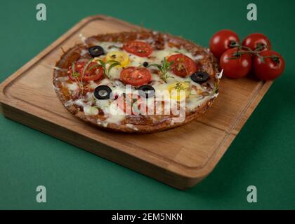 Pizza mit schwachem Keto und Mozzarella und Tomatenkruste mit Käsefüllung. Statt dessen aus Mandelmehl und Mozzarella gebackener Kuchen mit niedrigem Karbbenketo Stockfoto