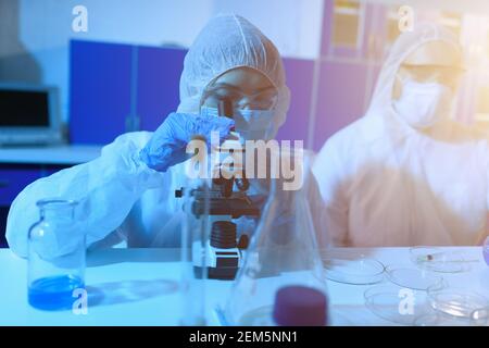 Der Arzt im Labor analysiert Proben unter einem Mikroskop. Pharmazeutisches Behandlungskonzept. Stockfoto