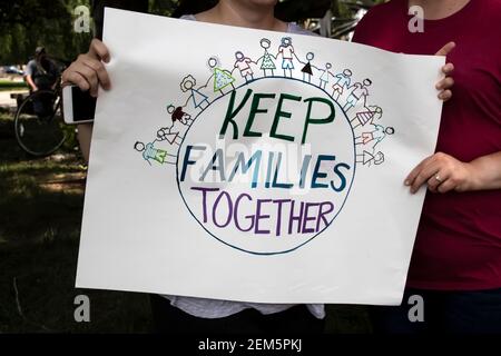 Zwei Frauen am Protest halten selbstgemachte Zeichen zusammen, die sagt Halten Sie Familien zusammen mit Welt und Familien halten Hände auf IT - abgeschnitten und selecti Stockfoto