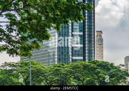 Futuristischer Finanzturm und Bäume im Park vor dem Gebäude Stockfoto