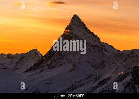 Eine mittlere Höhenansicht des Sonnenuntergangs hinter dem Matterhorn und den Schweizer alpen. Stockfoto