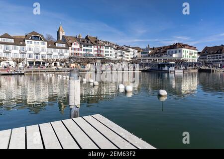 rapperswil jona, sankt gallen, schweiz - 20. februar 2021: Strandpromenade, fotografiert vom Bootssteg, viele Häuser und Hotels für die Nacht Stockfoto