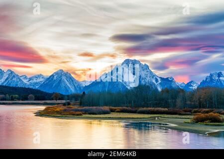 Malerischer Blick auf die großen tetons glühend blau in diesem Herbst Sonnenuntergang. Schöne Reflexionen eine glatte im Wasser Vordergrund von langer Belichtung Stockfoto