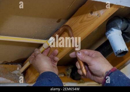 Wartung Klempner Service unter Hausbadezimmer in Reparatur von Kunststoff Polypropylen Wasserleitungen in Loch Wand weichen Fokus Stockfoto