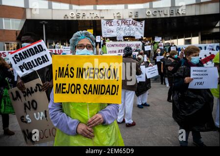 Madrid, Spanien. Februar 2021, 24th. Gesundheitshelfer protestieren mit Plakaten gegen Prekarität vor dem Krankenhaus 12 de Octubre und fordern bessere Arbeitsbedingungen und gegen ihre Misshandlung während der Coronavirus-Pandemie (CIVID-19). Gesundheitshelfer tragen Müllsäcke als Symbol des Protests. Quelle: Marcos del Mazo/Alamy Live News Stockfoto