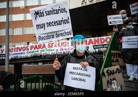 Madrid, Spanien. Februar 2021, 24th. Gesundheitshelfer protestieren mit Plakaten gegen Prekarität vor dem Krankenhaus 12 de Octubre und fordern bessere Arbeitsbedingungen und gegen ihre Misshandlung während der Coronavirus-Pandemie (CIVID-19). Gesundheitshelfer tragen Müllsäcke als Symbol des Protests. Quelle: Marcos del Mazo/Alamy Live News Stockfoto