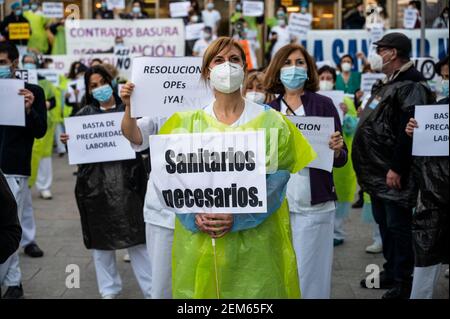 Madrid, Spanien. Februar 2021, 24th. Gesundheitshelfer protestieren mit Plakaten gegen Prekarität vor dem Krankenhaus 12 de Octubre und fordern bessere Arbeitsbedingungen und gegen ihre Misshandlung während der Coronavirus-Pandemie (CIVID-19). Gesundheitshelfer tragen Müllsäcke als Symbol des Protests. Quelle: Marcos del Mazo/Alamy Live News Stockfoto