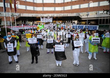 Madrid, Spanien. Februar 2021, 24th. Gesundheitshelfer protestieren mit Plakaten gegen Prekarität vor dem Krankenhaus 12 de Octubre und fordern bessere Arbeitsbedingungen und gegen ihre Misshandlung während der Coronavirus-Pandemie (CIVID-19). Gesundheitshelfer tragen Müllsäcke als Symbol des Protests. Quelle: Marcos del Mazo/Alamy Live News Stockfoto