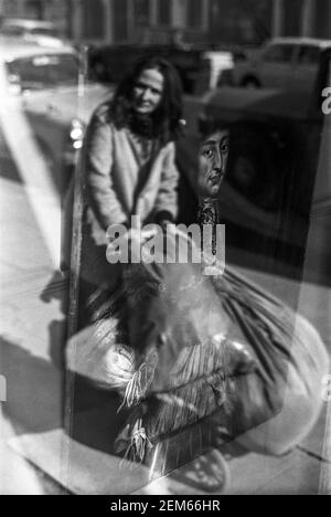 Großbritannien, West London, Notting Hill, 1973. Reflexionen in einem Schaufenster verkaufen Antiquitäten. Stockfoto