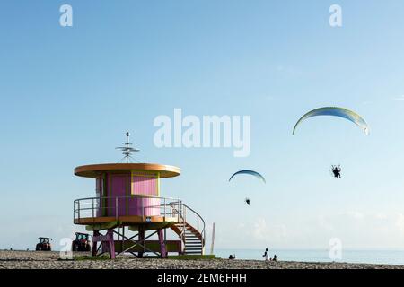 Zwei motorbetriebene Gleitschirme fliegen über einen der legendären Rettungsschwimmer-Türme in South Beach, Miami, Florida Stockfoto