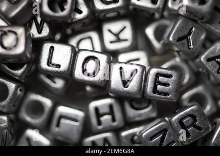 Nahaufnahme des Wortes Liebe in Silber geschrieben Metallperlen Stockfoto