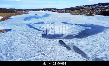 Luftdrohnenaufnahme eines Sees mit Eismuster im Winter In Bayern Stockfoto