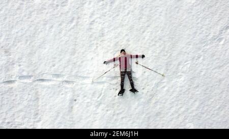 Luftdrohne Aufnahme von Frau Schneeschuhwandern im Schnee liegen Stockfoto