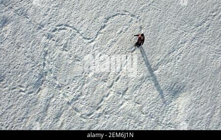 Luftaufnahme mit einer Drohne eines Schneeschulläufers Eine Spur in Form eines Herzens in Der Schnee Stockfoto