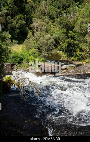 Die starke Wasserströmung von kristallklarem Wasser aus Paraibuna Fluss fließt über Felsformationen in Serra do Mar (Sea Ridge) dichten Wald. Stockfoto