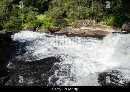 Die starke Wasserströmung von kristallklarem Wasser aus Paraibuna Fluss fließt über Felsformationen in Serra do Mar (Sea Ridge) dichten Wald. Stockfoto