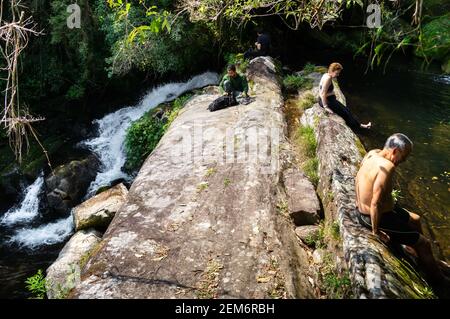 Touristen entspannen und genießen die Umgebung von Ipiranguinha Wasserfall nach dem langen Wandern. Cascade in Serra do Mar Landgut Park gelegen. Stockfoto