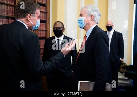 Washington, DC. Februar 2021, 24th. William Burns, rechts, Nominierter für den Direktor der Central Intelligence Agency, spricht mit dem US-Senator Mark Warner (Demokrat von Virginia), dem Vorsitzenden des US Senate Select Committee on Intelligence, nach seiner Bestätigungsverhandlung im Russell Senate Office Building auf dem Capitol Hill in Washington, DC, am Mittwoch, den 24. Februar 2021.Quelle: Tom Williams/Pool via CNP – weltweite Nutzung Quelle: dpa/Alamy Live News Stockfoto