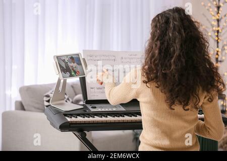 Junge Frau gibt Musikunterricht online zu Hause Stockfoto