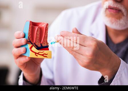 Alte Zahnarztlehrerin sitzt im Klassenzimmer Stockfoto