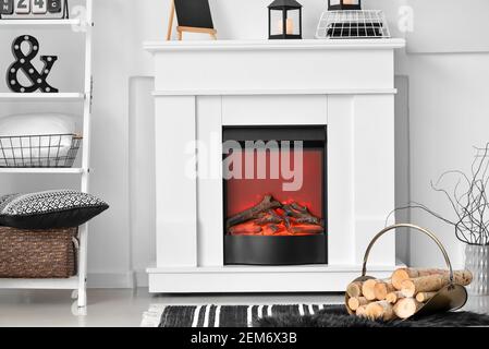Stilvoller Kaminsims mit Feuerholz auf der Innenseite des Wohnzimmers Stockfoto