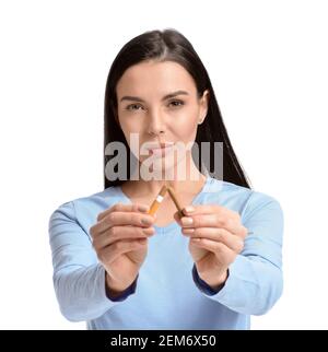 Junge Frau mit gebrochener Zigarette auf weißem Hintergrund. Konzept der Ablehnung von schlechten Gewohnheit Stockfoto
