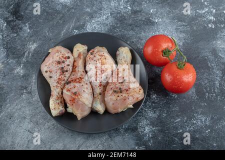 Frisches Gemüse mit Hähnchendrumsticks auf grauem Hintergrund Stockfoto