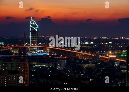 Langgeschwindigkeitsfoto des Industrial Ring Expressway und der Bhumibol Bridge. Stadtbild Bangkok bei Nacht, Gebäude im zentralen Geschäftsviertel. Stockfoto