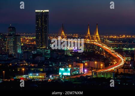 Langgeschwindigkeitsfoto des Industrial Ring Expressway und der Bhumibol Bridge. Stadtbild Bangkok bei Nacht, Gebäude im zentralen Geschäftsviertel. Stockfoto