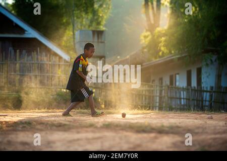 Chiang Mai / Thailand - 16. Jan 2016: Jungs spielen zum Spaß top. Spinning Tops sind eine Art thailändisches Spiel. Abends auf dem Land im Norden Thailands Stockfoto