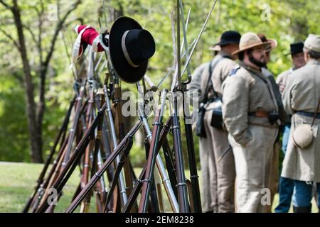 Marbury, Alabama/USA-28. April 2018: Gewehre aus der Bürgerkriegszeit mit Bajonetten, die mit unscharfem Bürgerkriegsreenakteuren im Hintergrund angebracht sind. Stockfoto