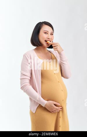 Eine schlanke schwangere Frau hält ein köstliches gesundes Brot Stockfoto