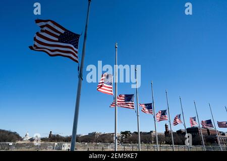 Washington, USA. Februar 2021, 24th. US-Nationalflaggen fliegen auf Halb-Mitarbeiter am Washington Monument, um die mehr als eine halbe Million US-Menschenleben zu betrauern, die COVID-19 am 24. Februar 2021 in Washington, DC, USA, verloren hat. Quelle: Liu Jie/Xinhua/Alamy Live News Stockfoto